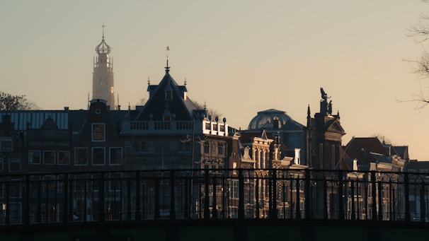 A bustling European city skyline at sunset with office buildings and cranes.