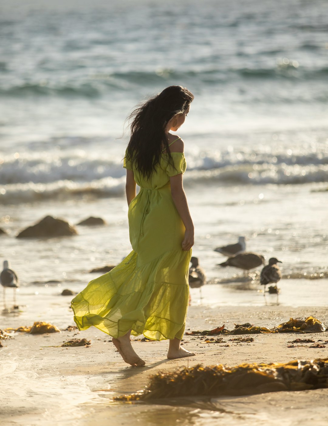 woman in yellow sleeveless dress standing on beach during daytime