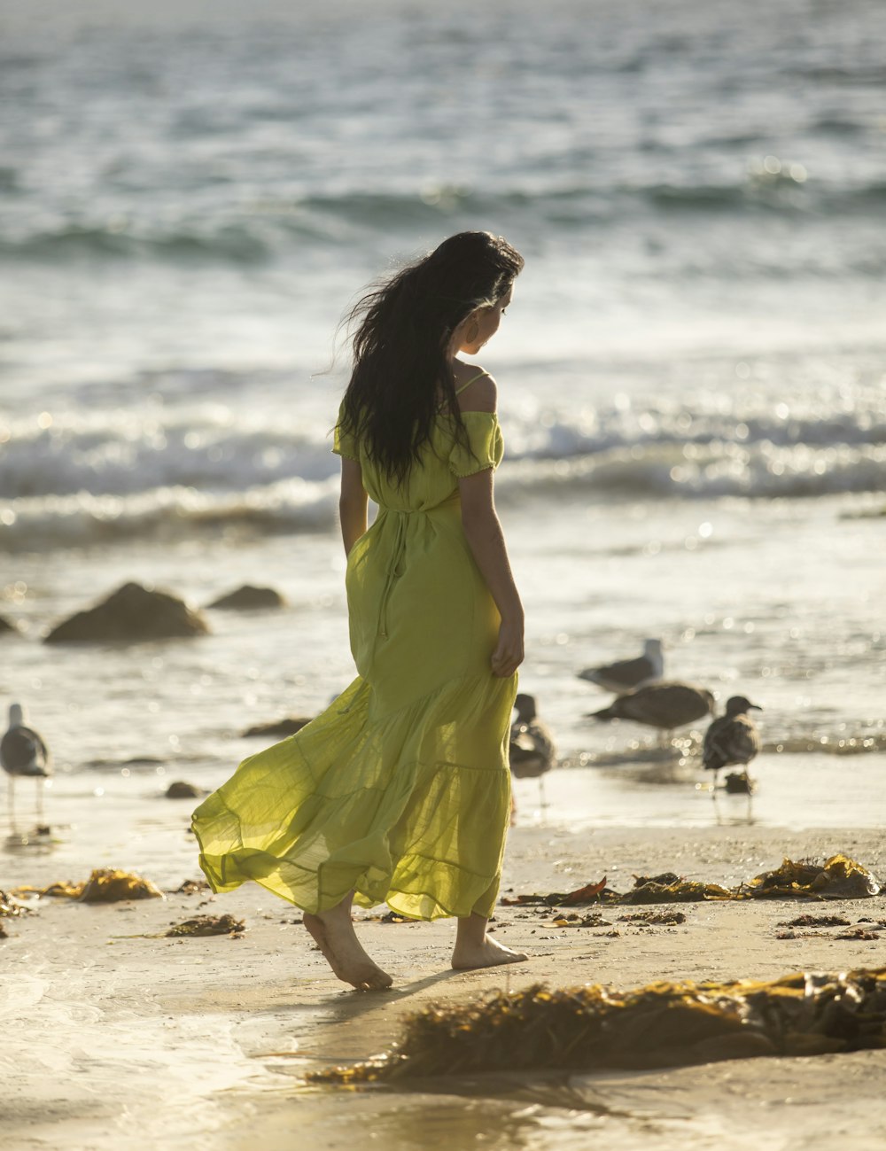 woman in yellow sleeveless dress standing on beach during daytime