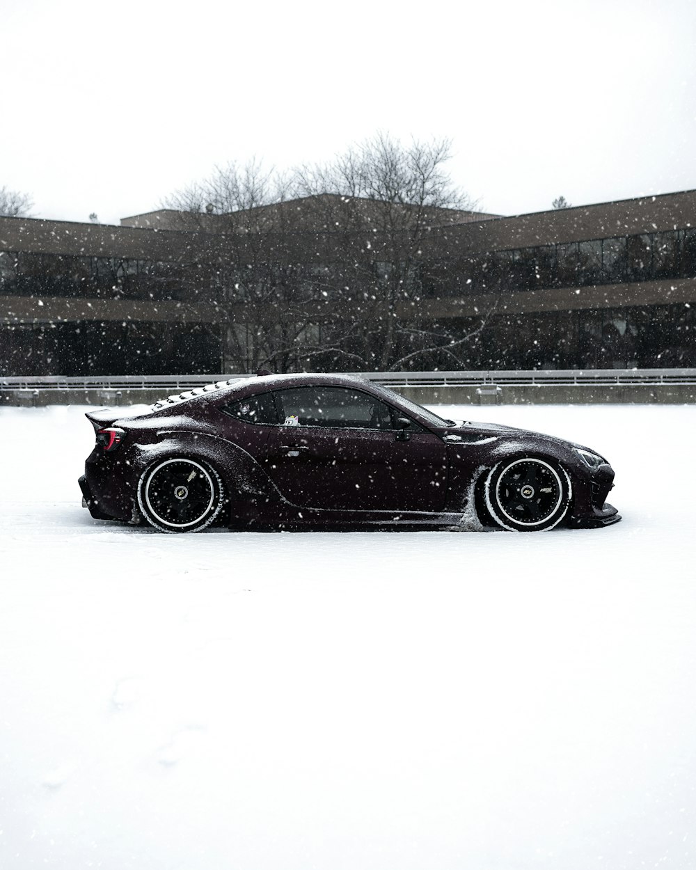 black coupe on snow covered road during daytime