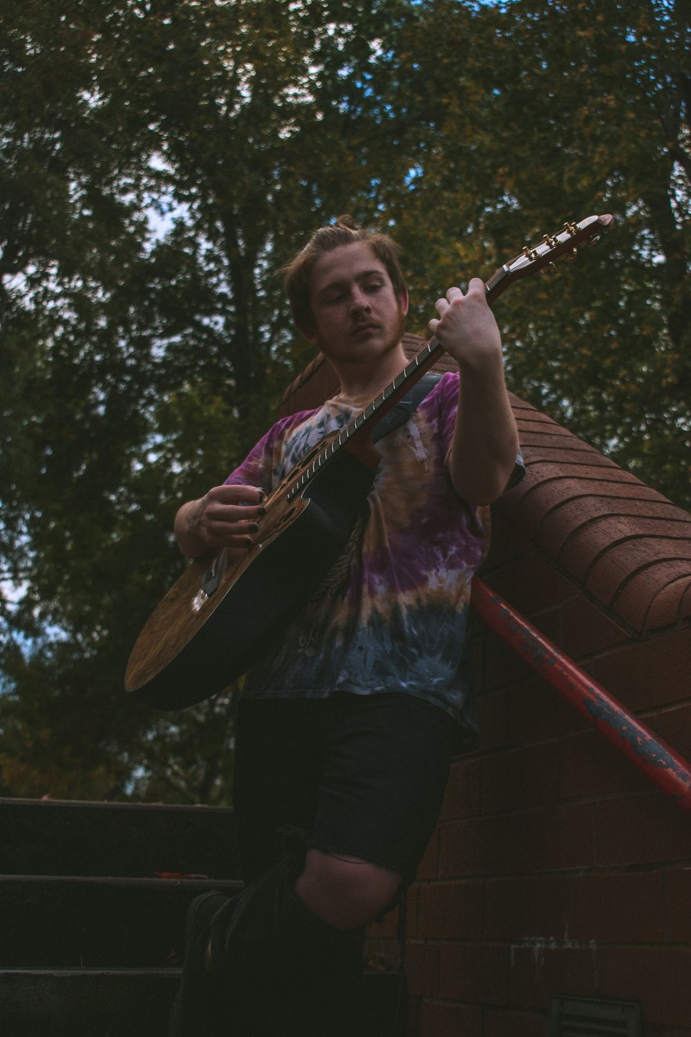 woman in purple and white long sleeve shirt holding brown acoustic guitar