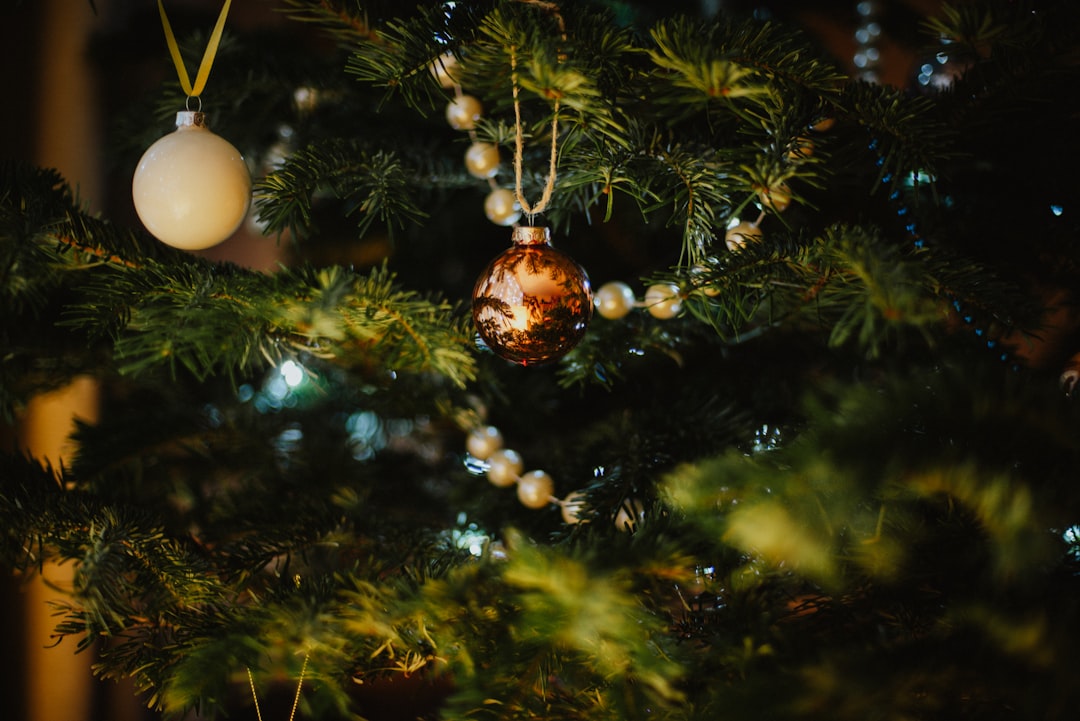gold and white baubles on green christmas tree
