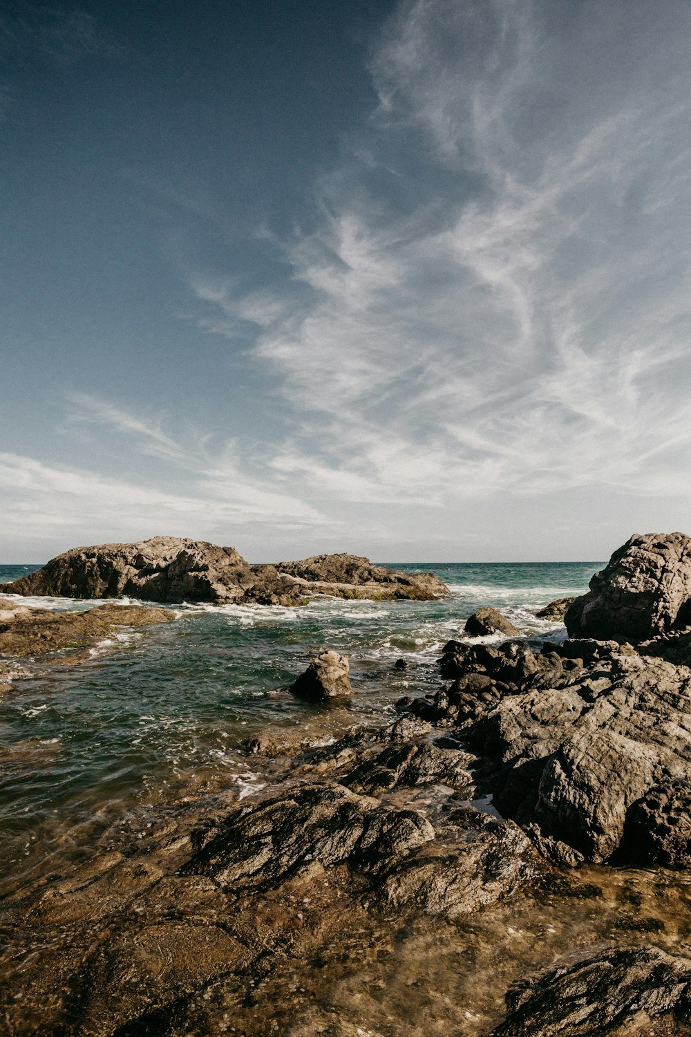 rocky shore under blue sky during daytime