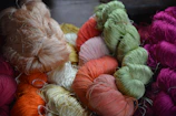 Close-up of colorful silk skeins arranged neatly on a wooden table.