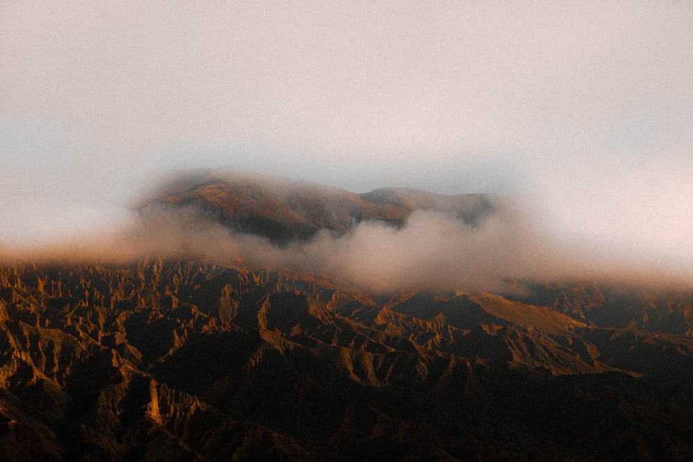 brown and green mountains under white clouds