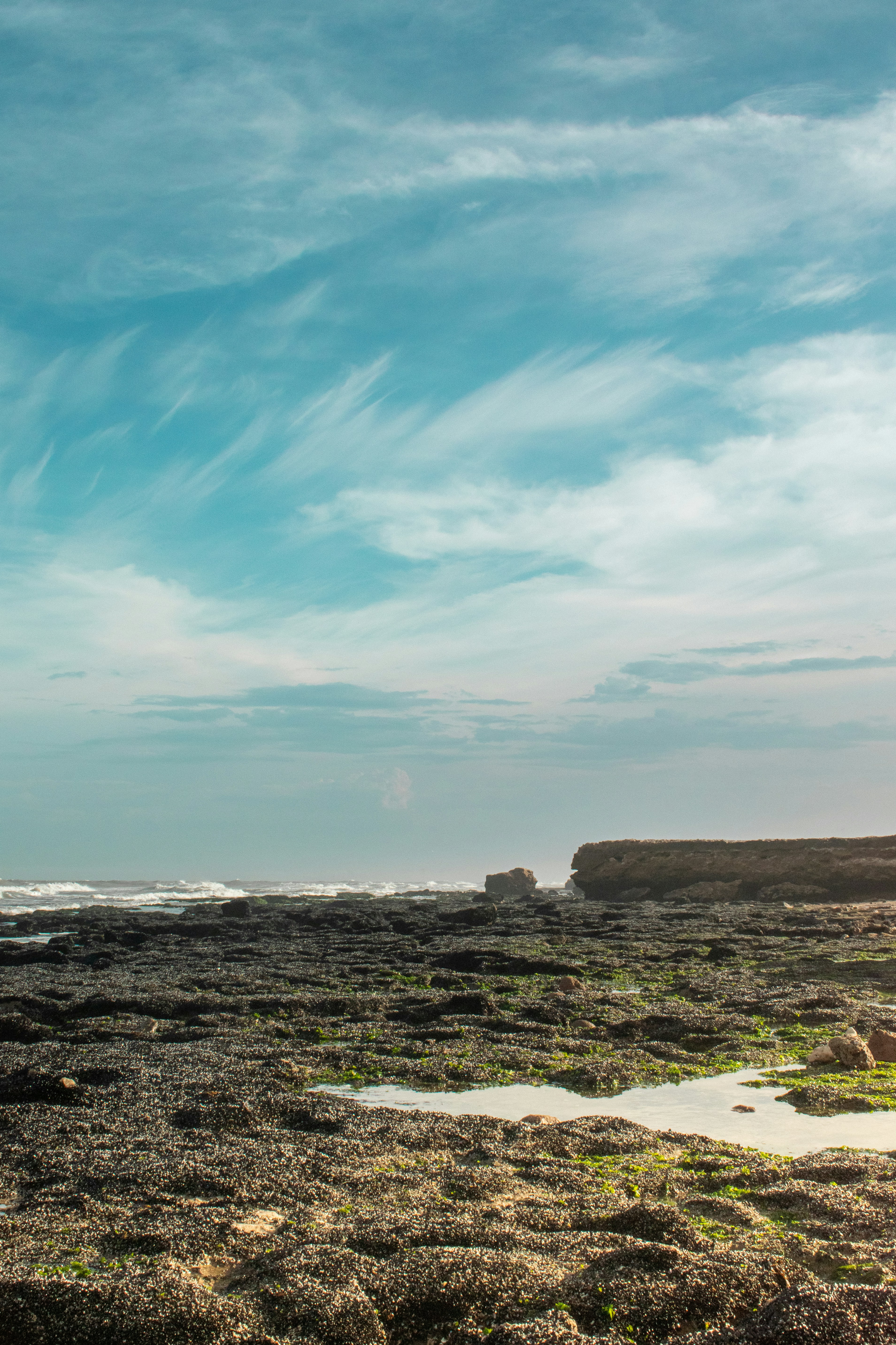 brown rock formation near body of water during daytime
