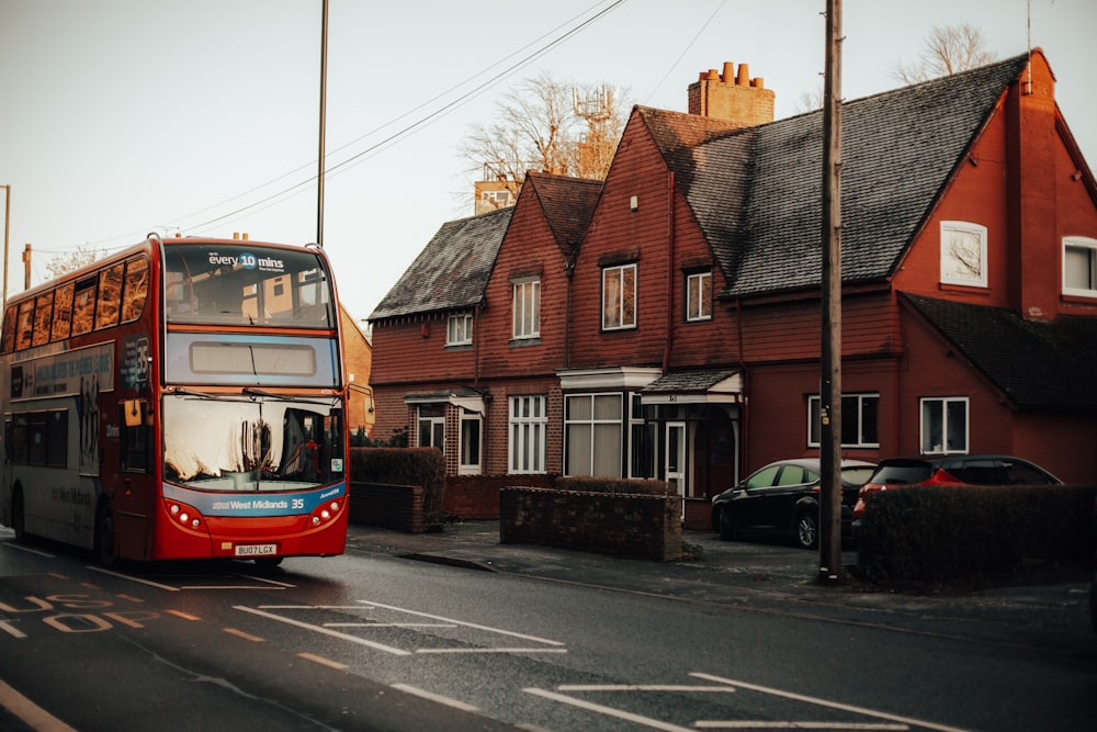 red and white bus on road near brown concrete building during daytime