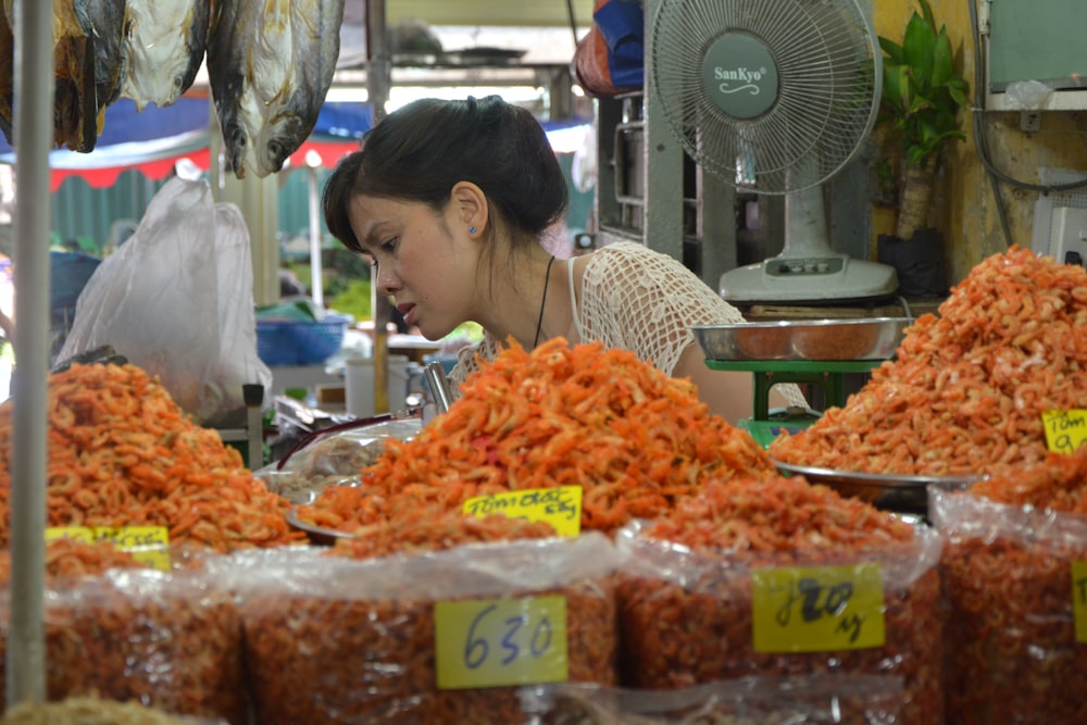 食べ物を見ている白いシャツの女性