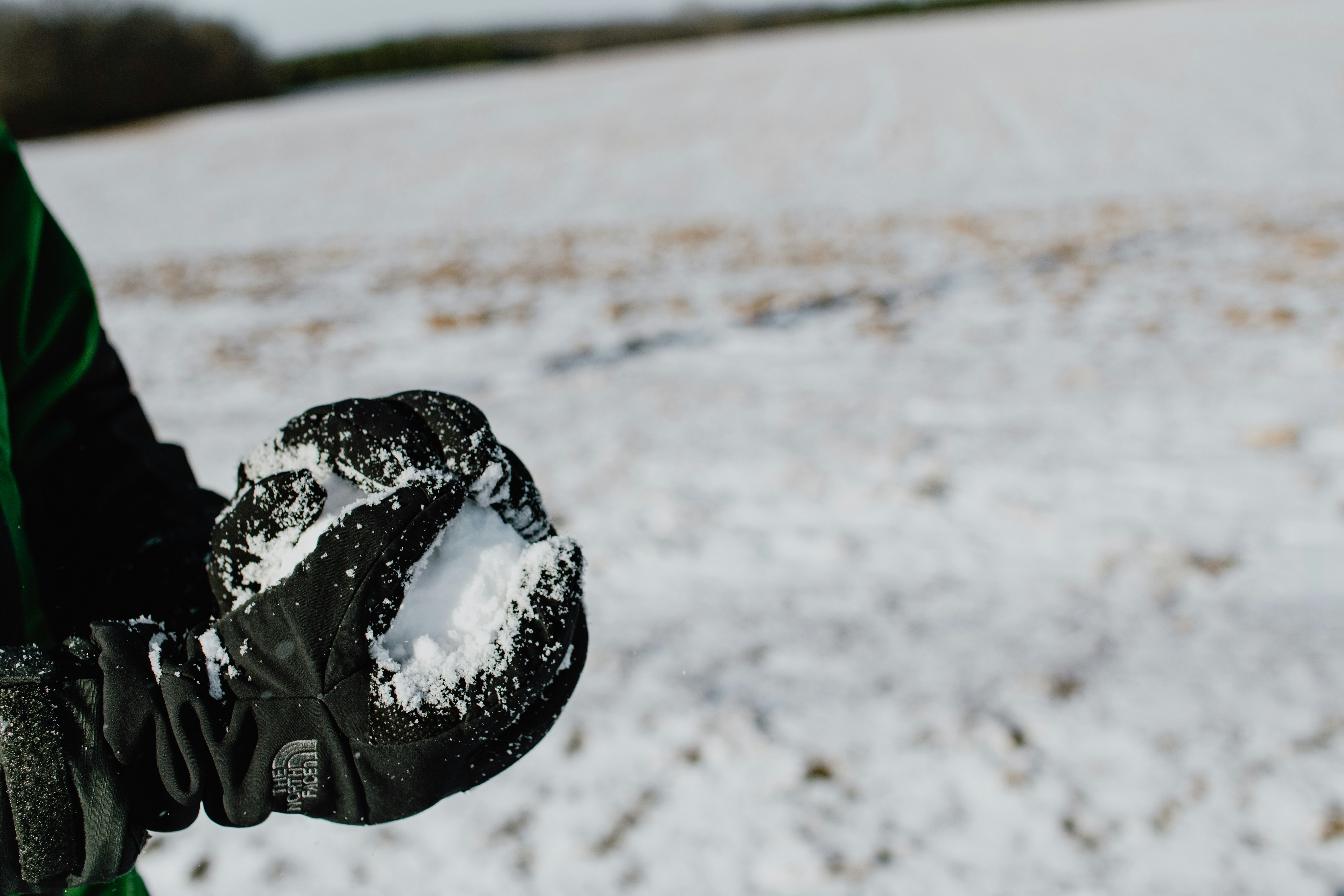 black heart shaped ornament on white sand snowball teams background