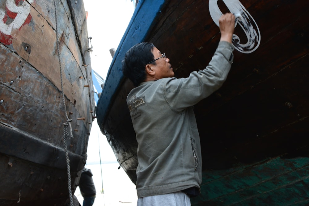 Mann in grauem Kapuzenpullover tagsüber auf dem Boot