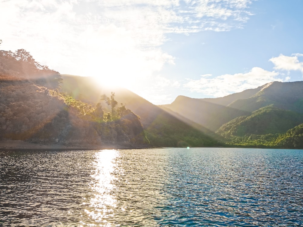 green mountains beside body of water during daytime