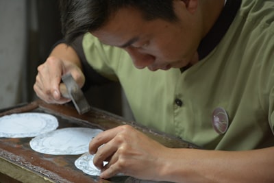 man in green button up shirt holding silver knife craftsman google meet background