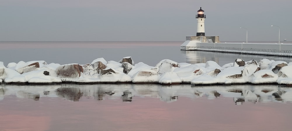 weiß-schwarzer Leuchtturm mit Schnee bedeckt