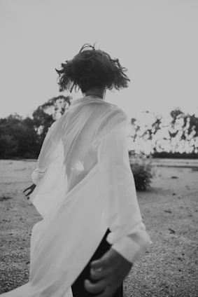 Black and white photo of a person wearing ragmuz clothing, running through an urban park at dawn.