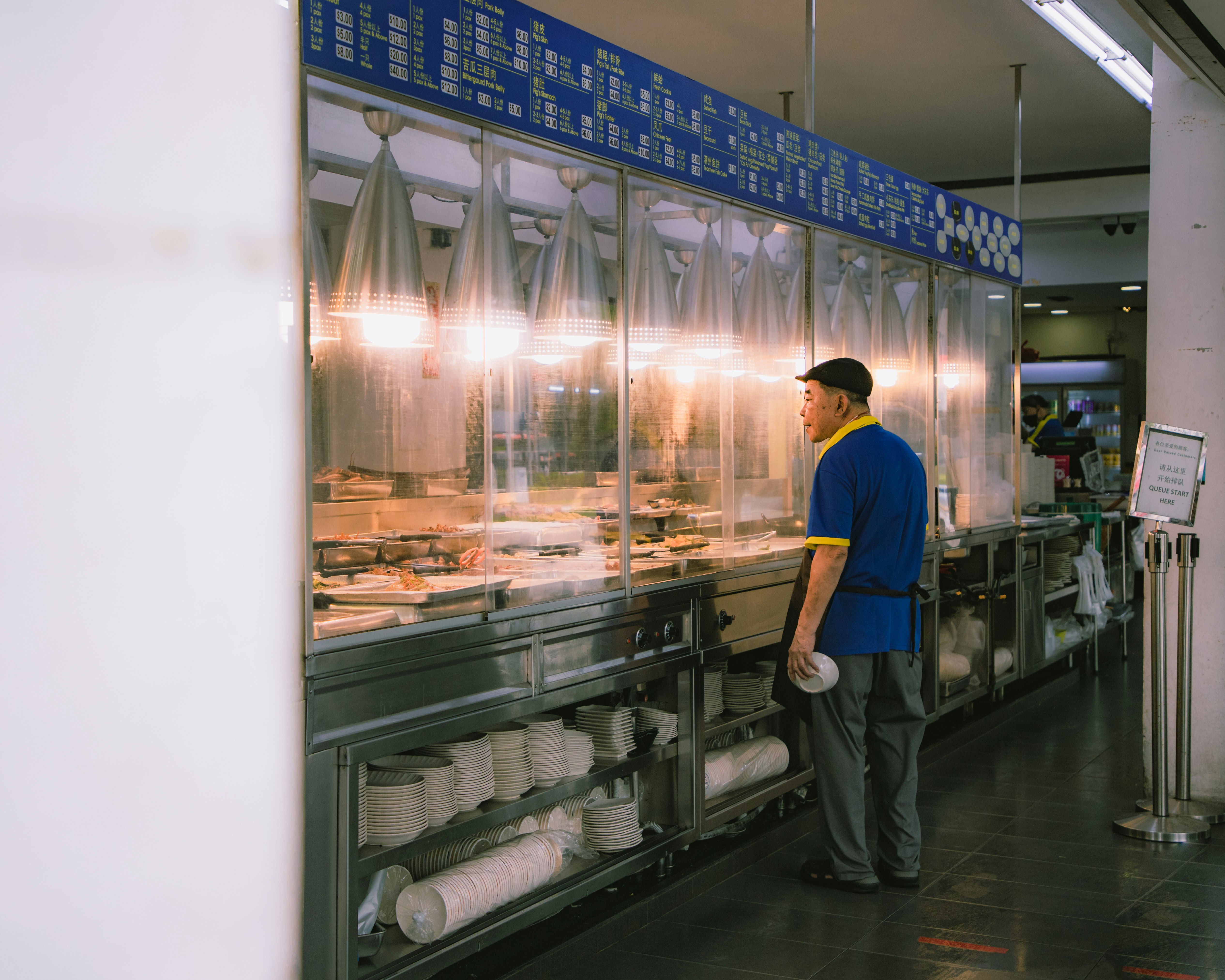 man in blue shirt standing in front of clear glass display counter