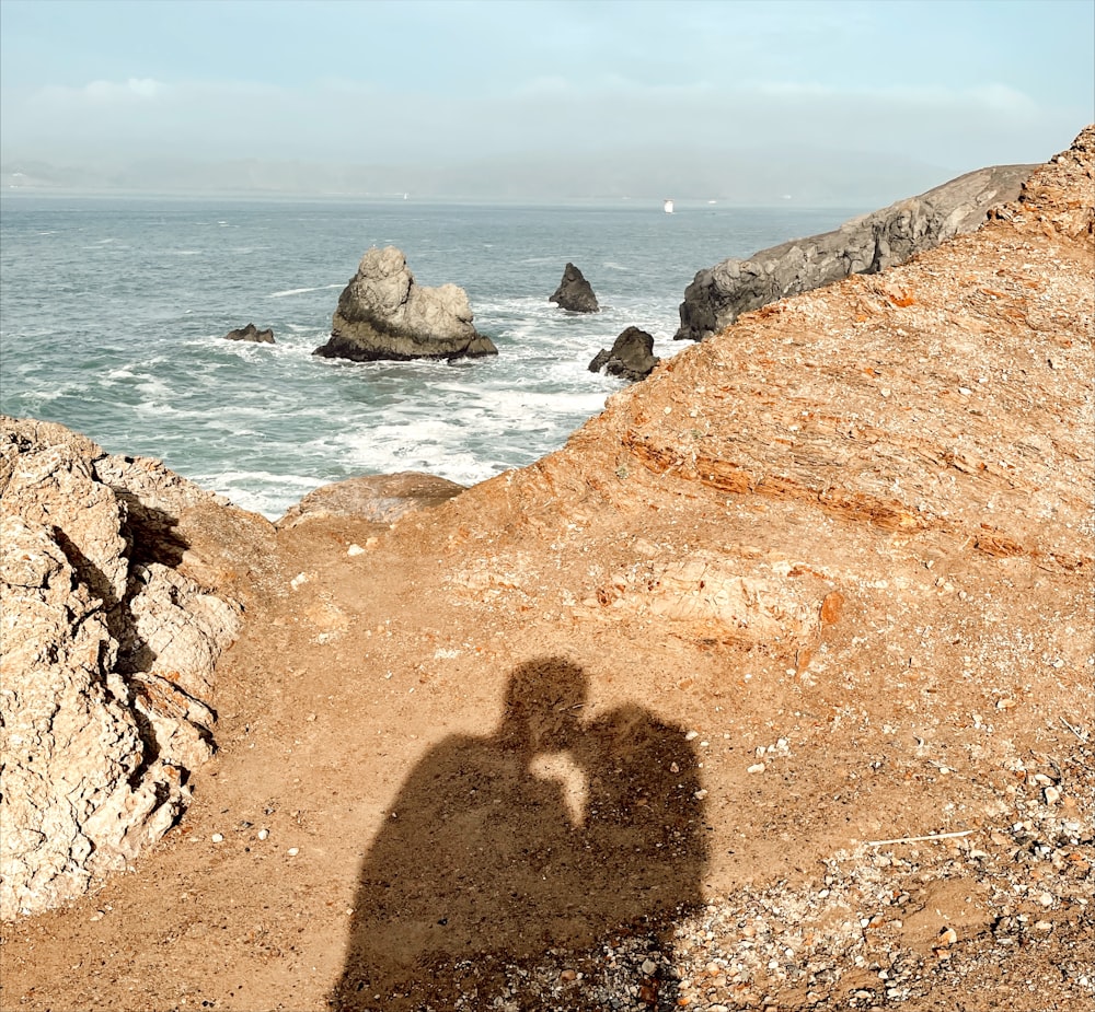 brown rock formation near body of water during daytime