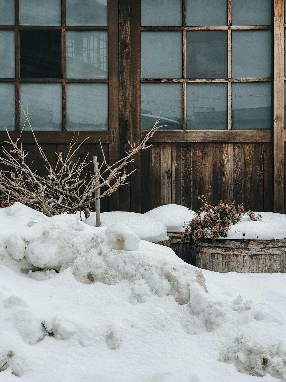 Ventana de vidrio con marco de madera marrón cubierta de nieve