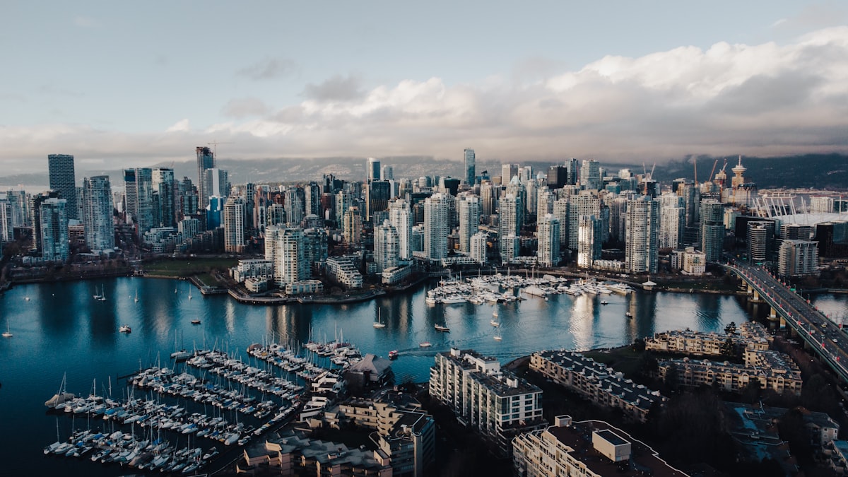 Vancouver British Columbia skyline with modern office buildings representing the city's growing technology sector and opportunities for AI and cybersecurity immigrants