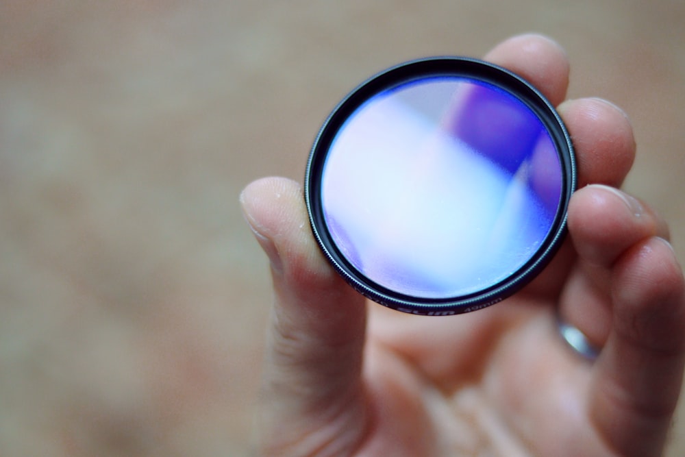 person holding round black and white lens