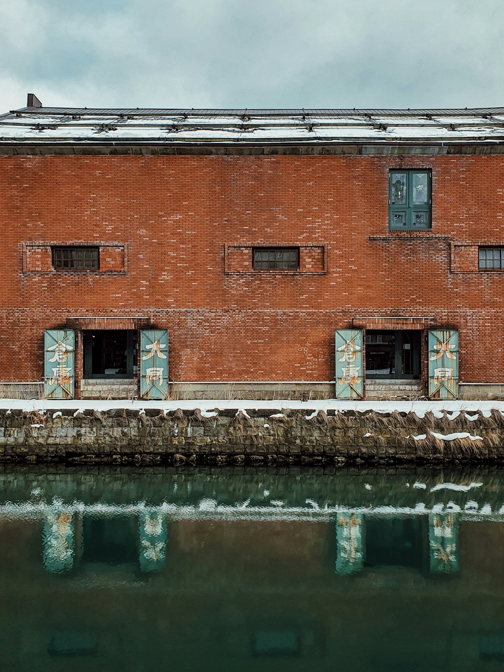 brown brick building beside body of water during daytime