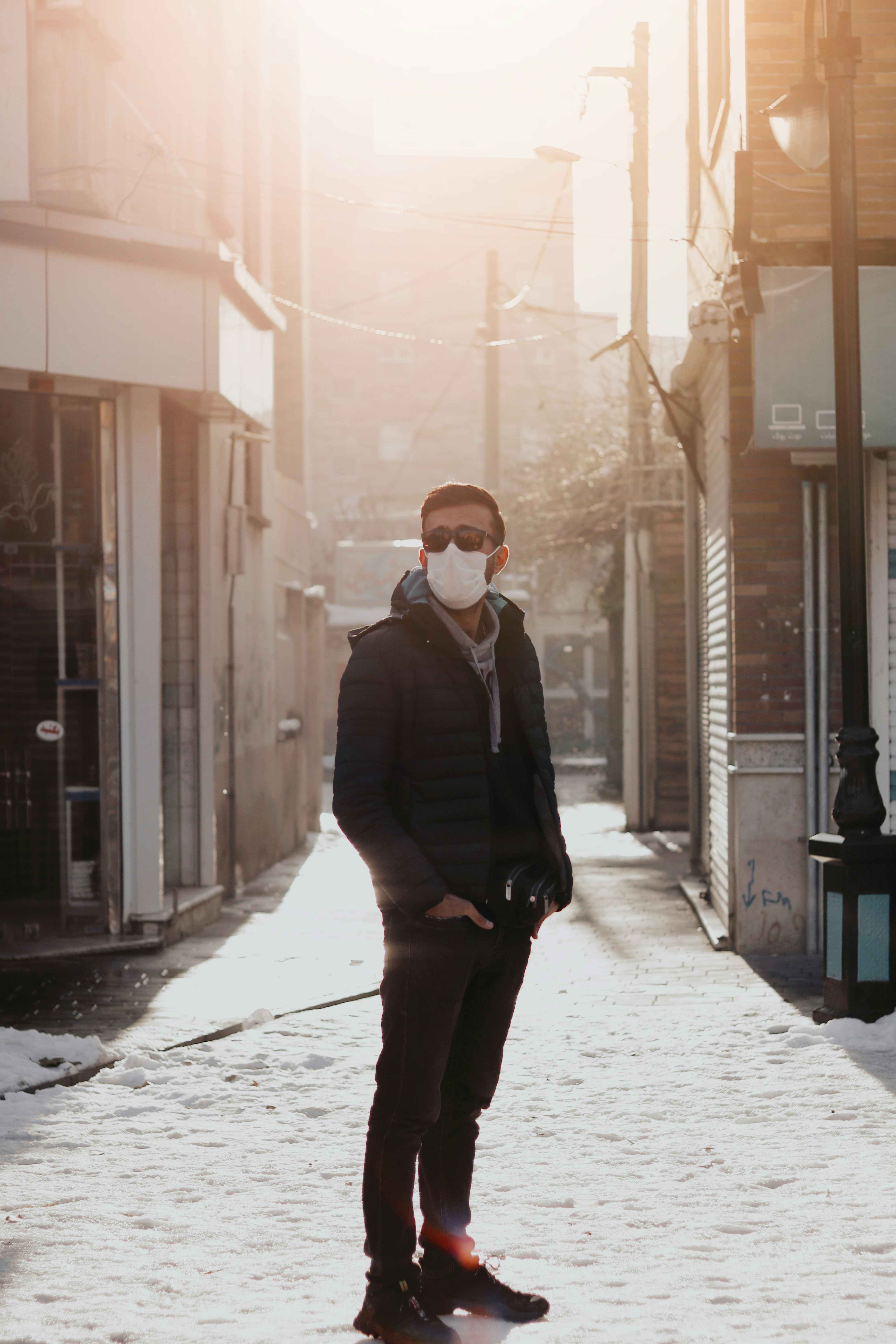 homem no terno preto de pé em azulejos de piso branco durante o dia