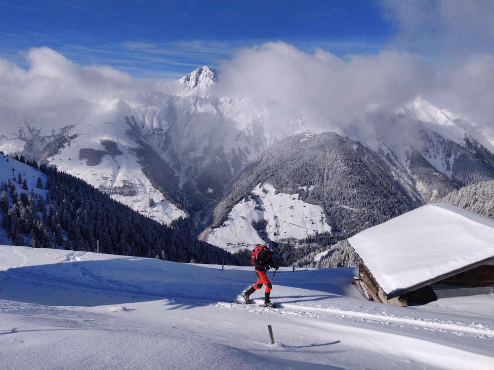 person in red jacket and black pants riding ski blades on snow covered mountain during daytime