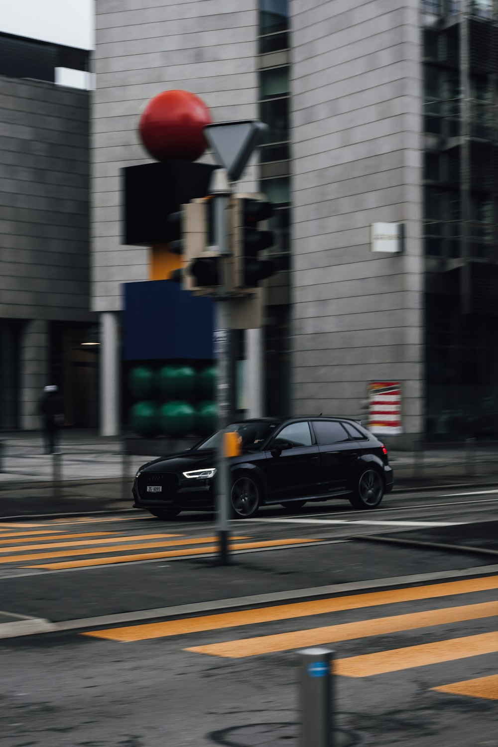 black sedan on pedestrian lane during daytime