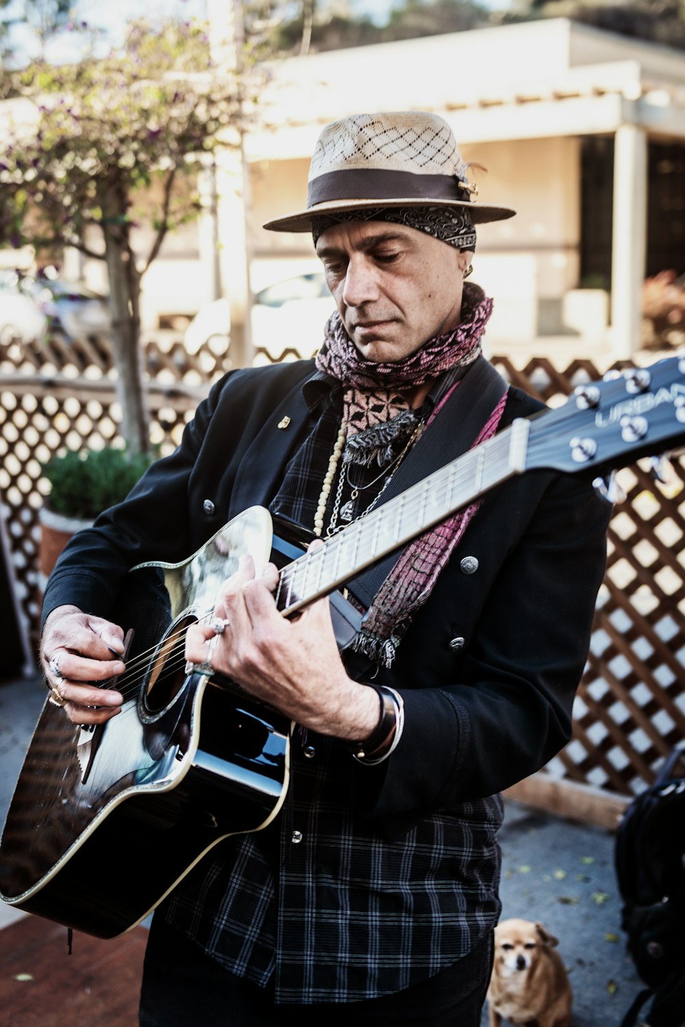 man in black coat playing white and black electric guitar