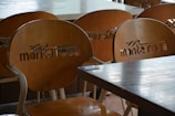 Set of wooden cafe chairs around a round table in a bright space.