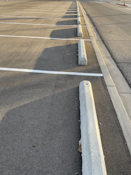 Freshly paved and sealed asphalt parking lot shining under sunlight.