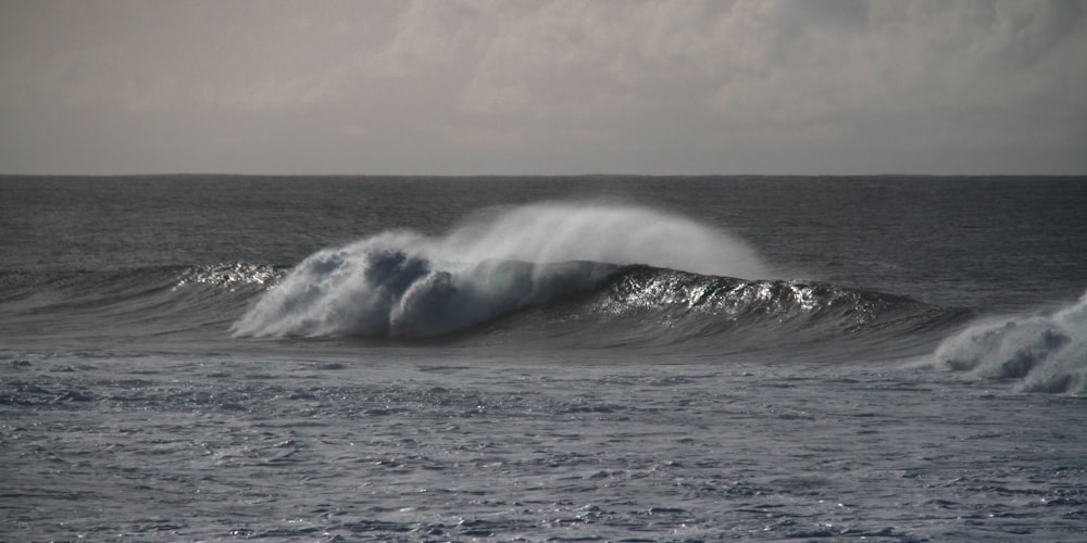 ocean waves under white sky during daytime