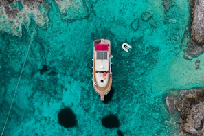 Panoramic shot of Mari Pintau’s crystal-clear turquoise waters taken from the deck of a moored boat