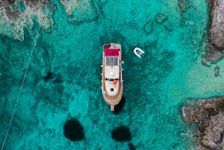 Panoramic shot of Mari Pintau’s crystal-clear turquoise waters taken from the deck of a moored boat