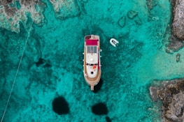 Close-up aerial view of a tourist boat cruising turquoise waters near Búzios.