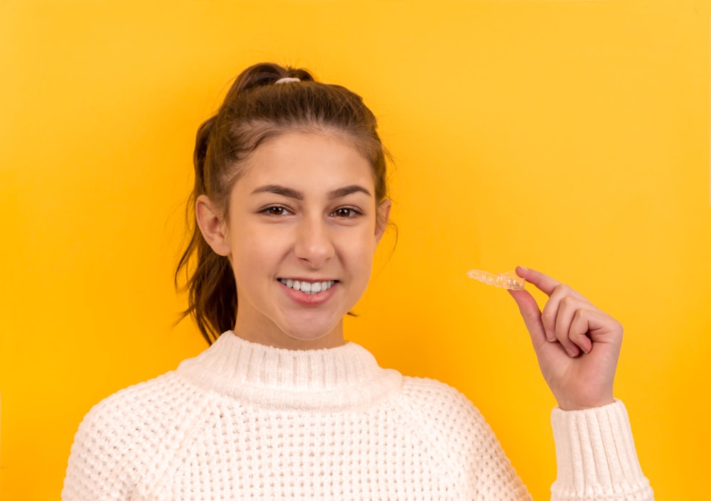 lächelnde Frau im weißen Strickpullover