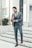 A stylish man in a tailored suit from Zenvy Mode Wear standing confidently on city steps.