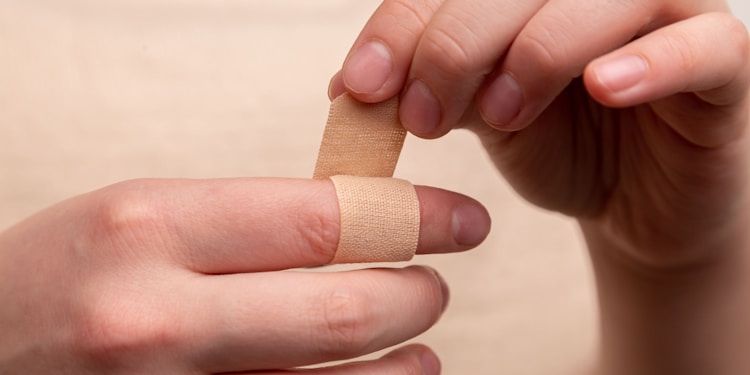 person with band aid on middle finger