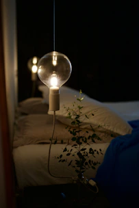 A relaxed bedroom scene with a glowing bedside lamp, gentle wall lights, and a soothing aroma diffuser.