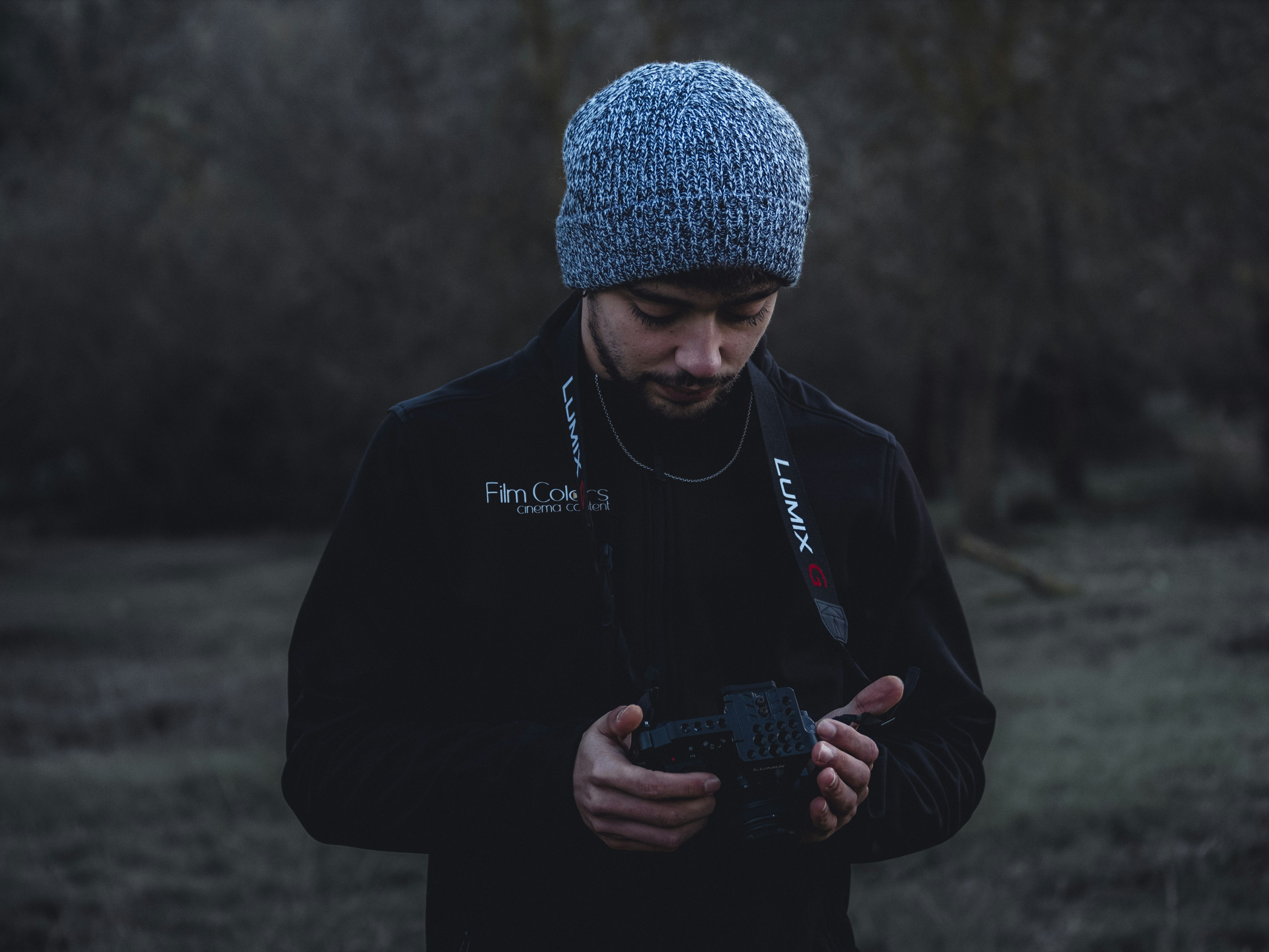 man in black jacket holding black smartphone