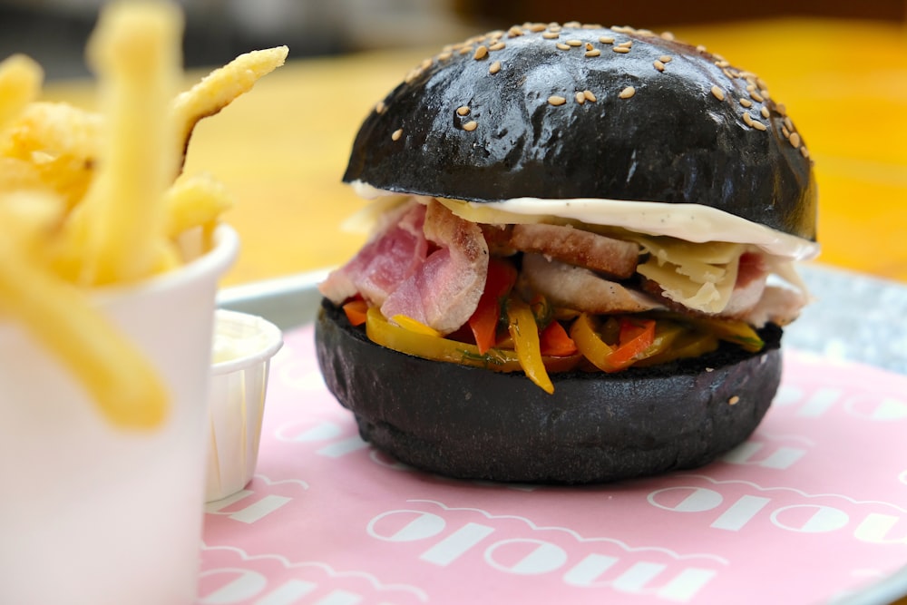 burger with patty and fries on white and pink ceramic plate