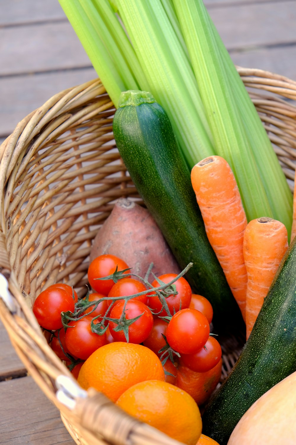 zanahorias y pepino en una canasta tejida marrón