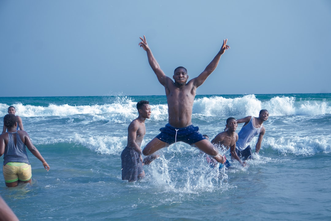 man in blue shorts jumping on water during daytime