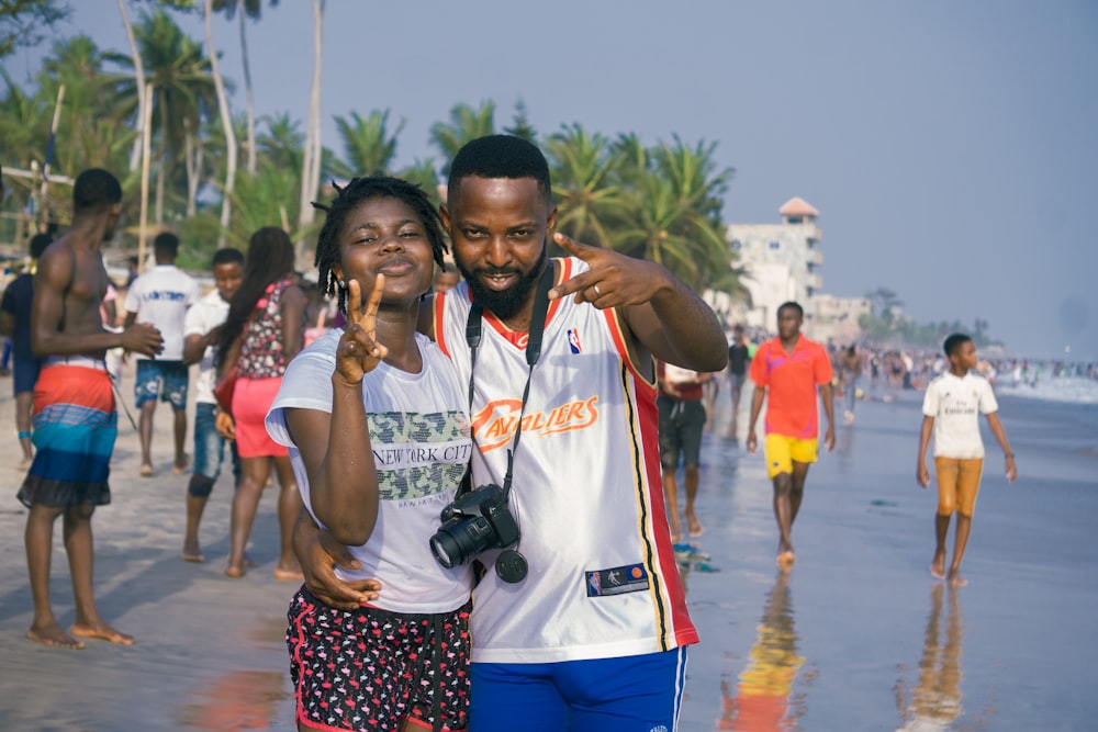 man in white and orange crew neck t-shirt standing beside woman in white t-shirt