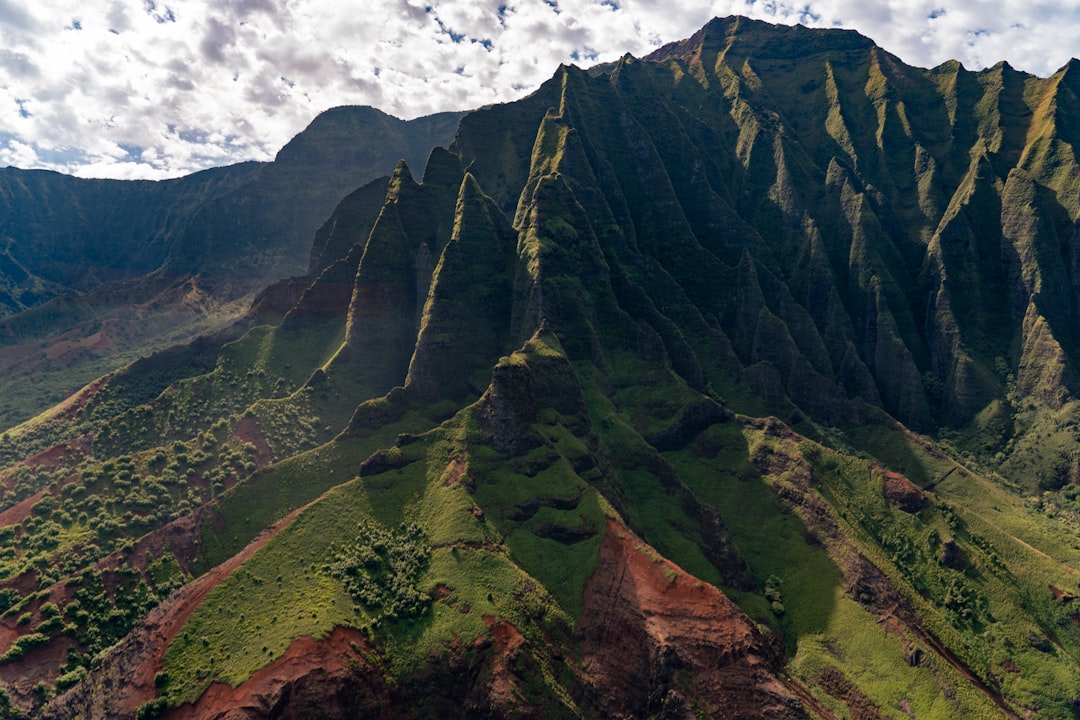 green and brown mountain under white clouds during daytime