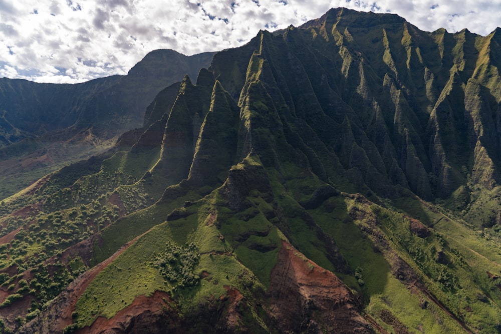 green and brown mountain under white clouds during daytime