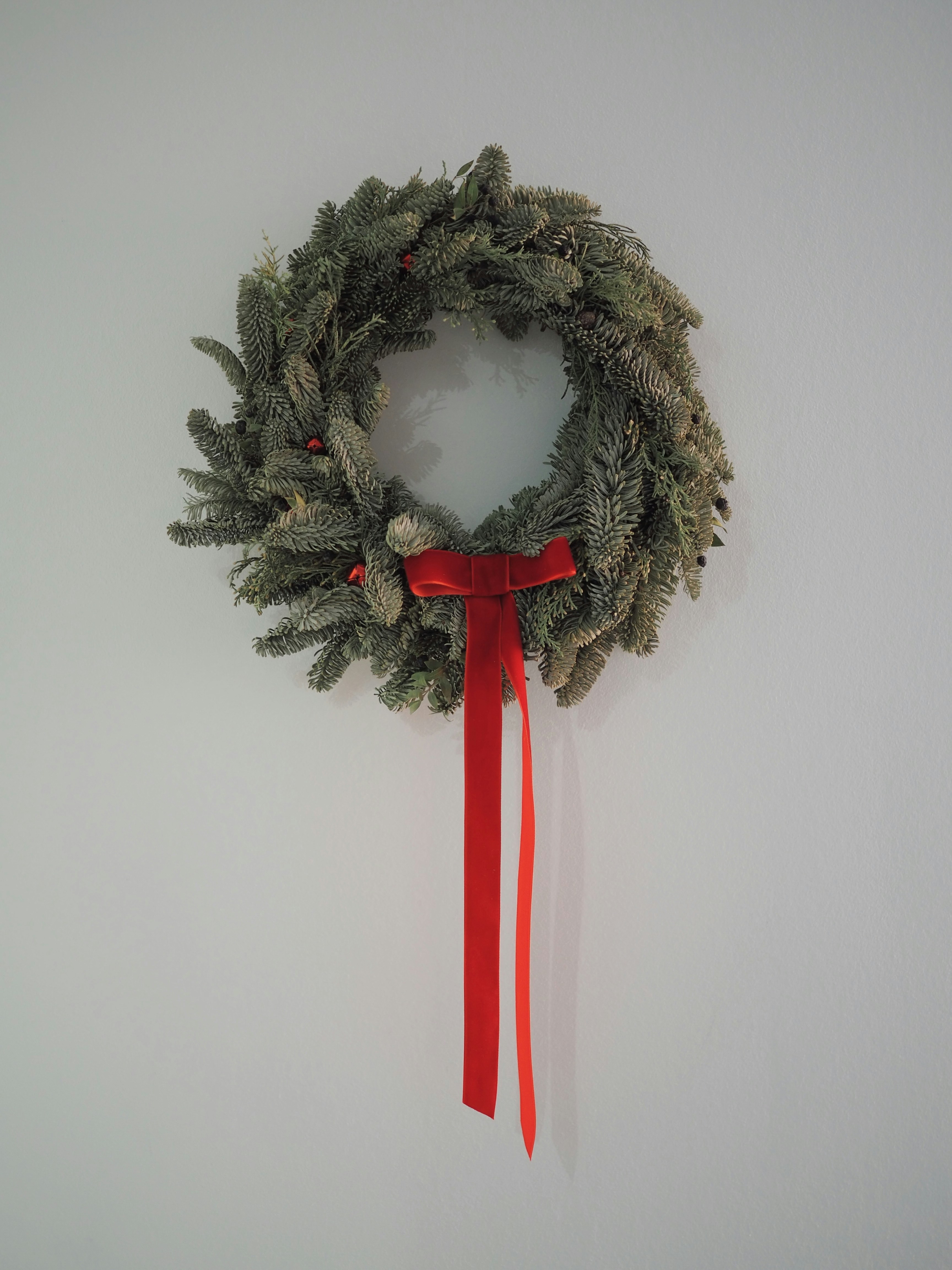 grüner und weißer Kranz an weißer Wand