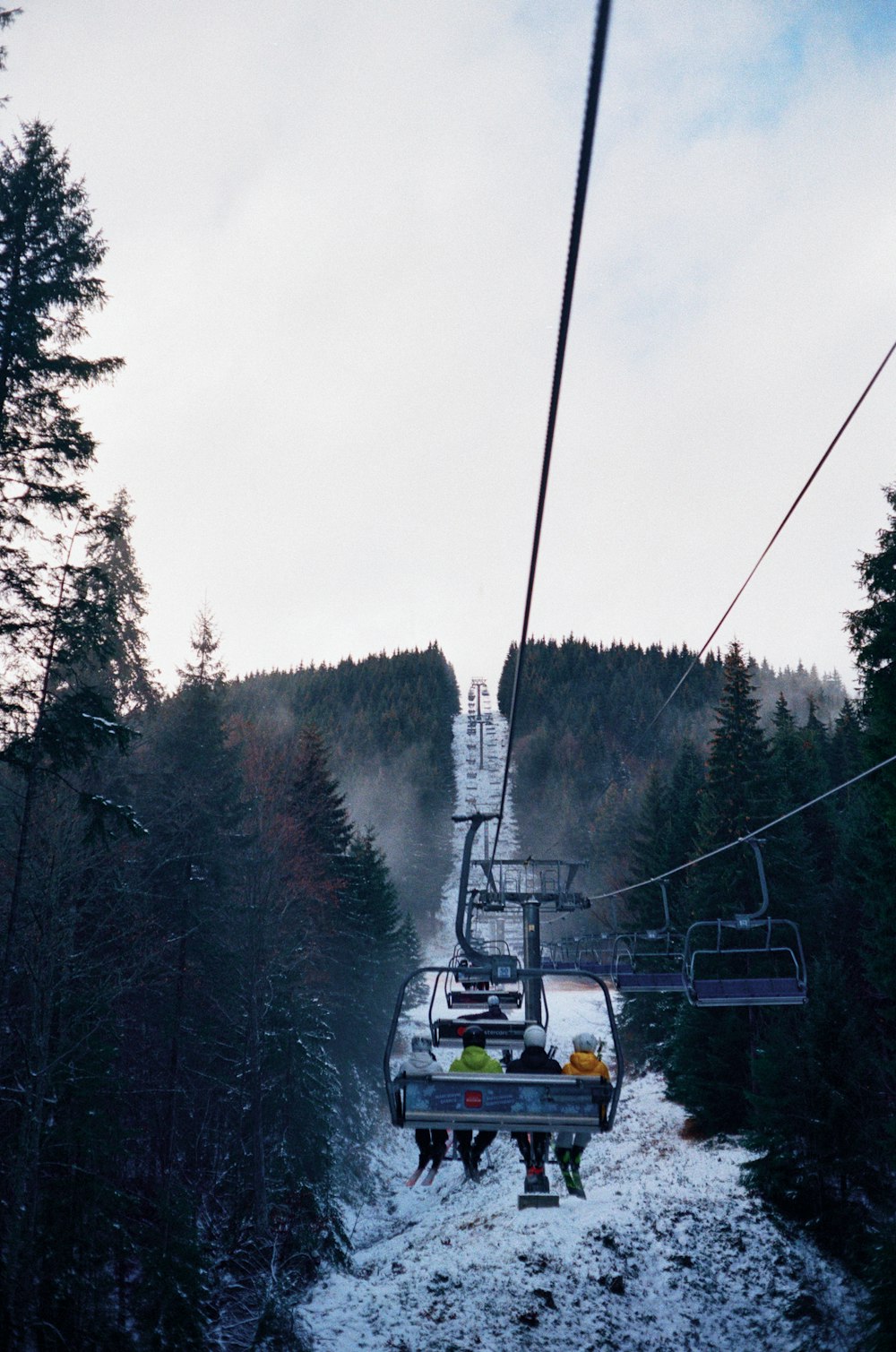 gelb-schwarze Seilbahn auf verschneitem Untergrund