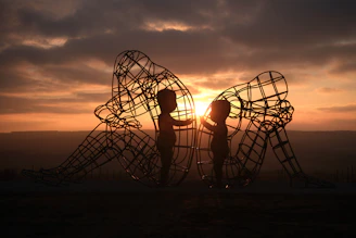 a couple of people that are standing in front of a sculpture