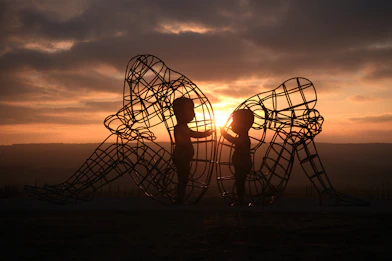 a couple of people that are standing in front of a sculpture