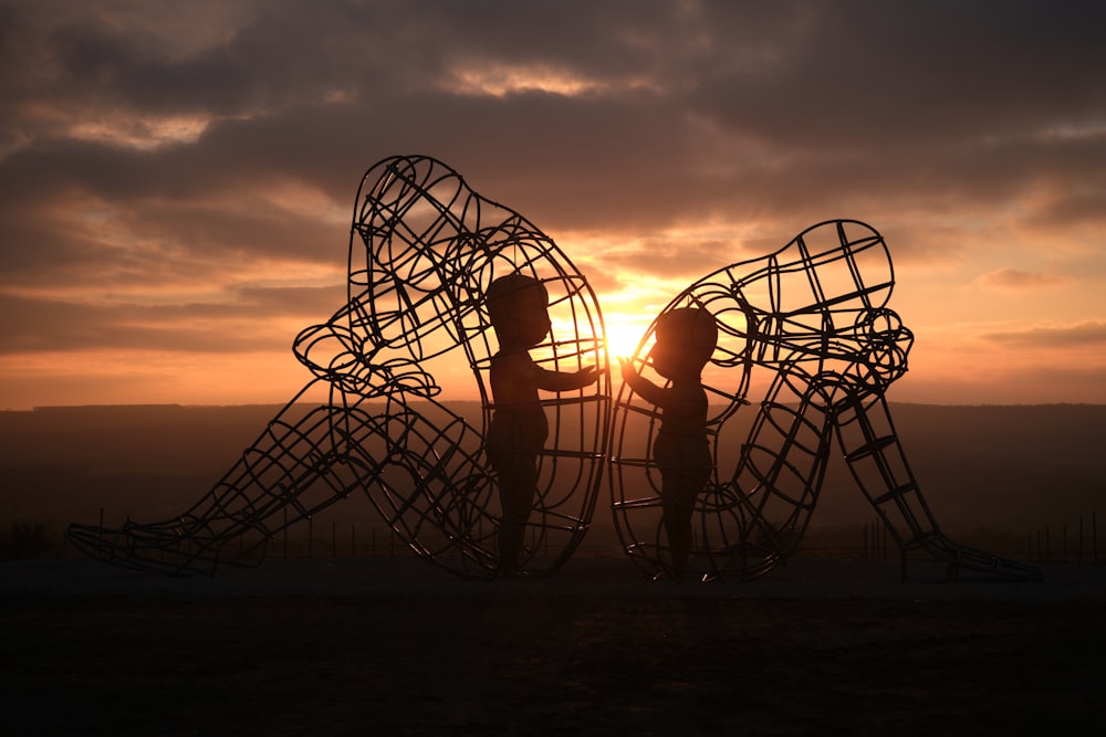 a couple of people that are standing in front of a sculpture